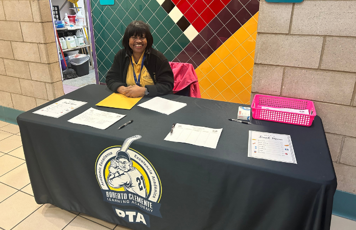a teacher sitting at the ticket table